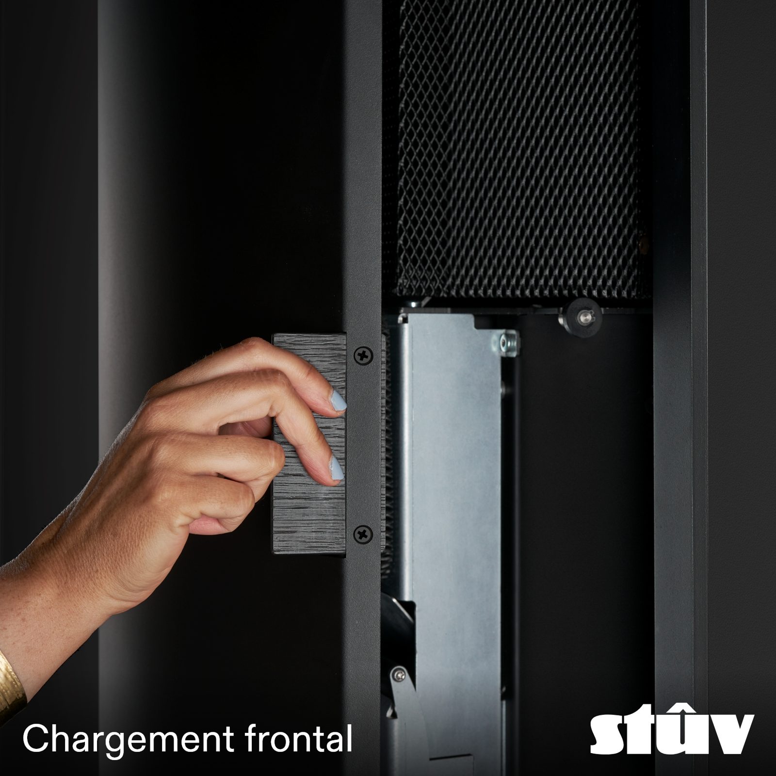 Main ouvrant la trappe de chargement frontale du Stûv sP20-in
